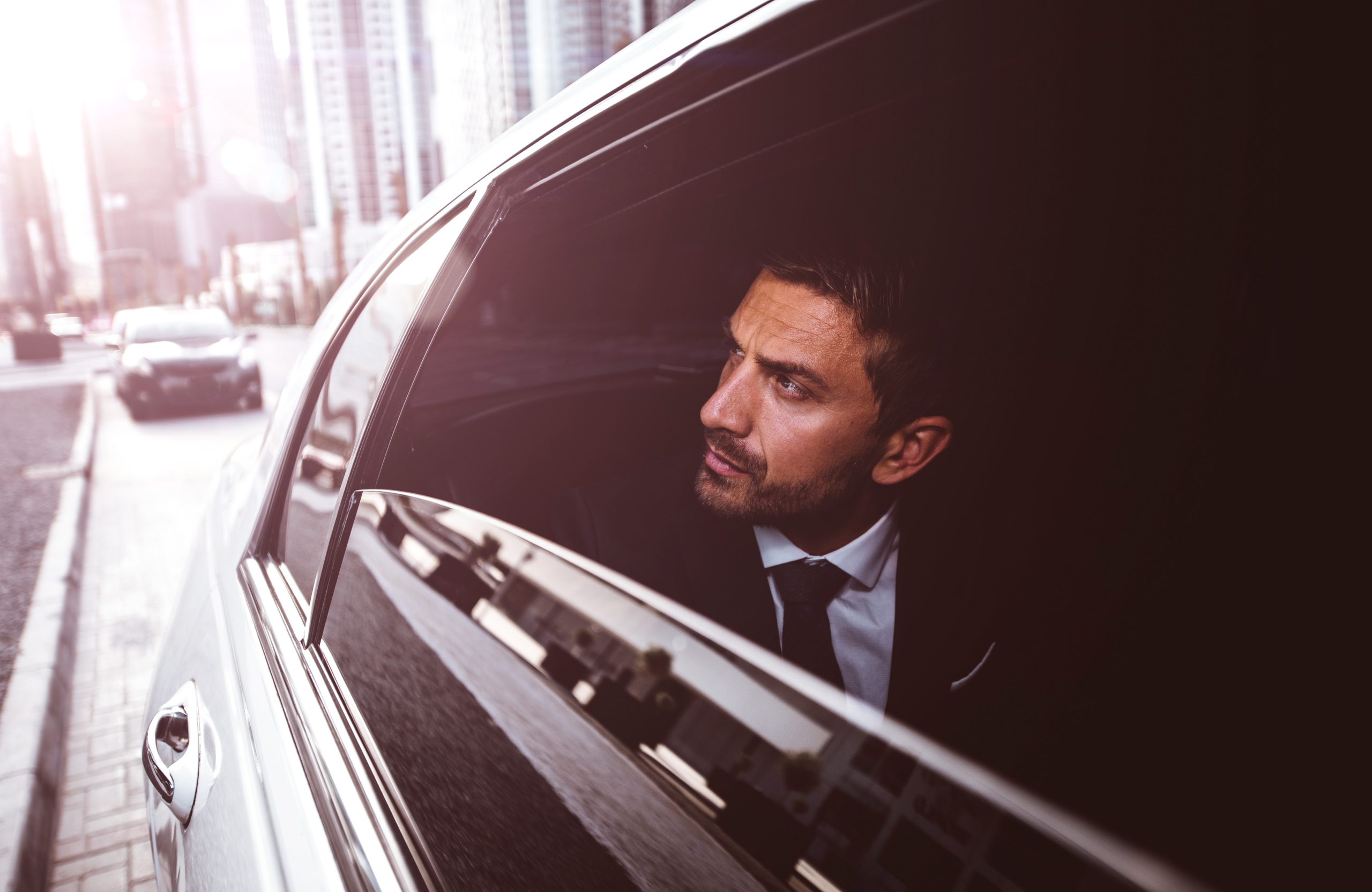 Business executive looking out the window of a Corporate Black Car Service during a premium airport luxury limousine ride in St. Louis