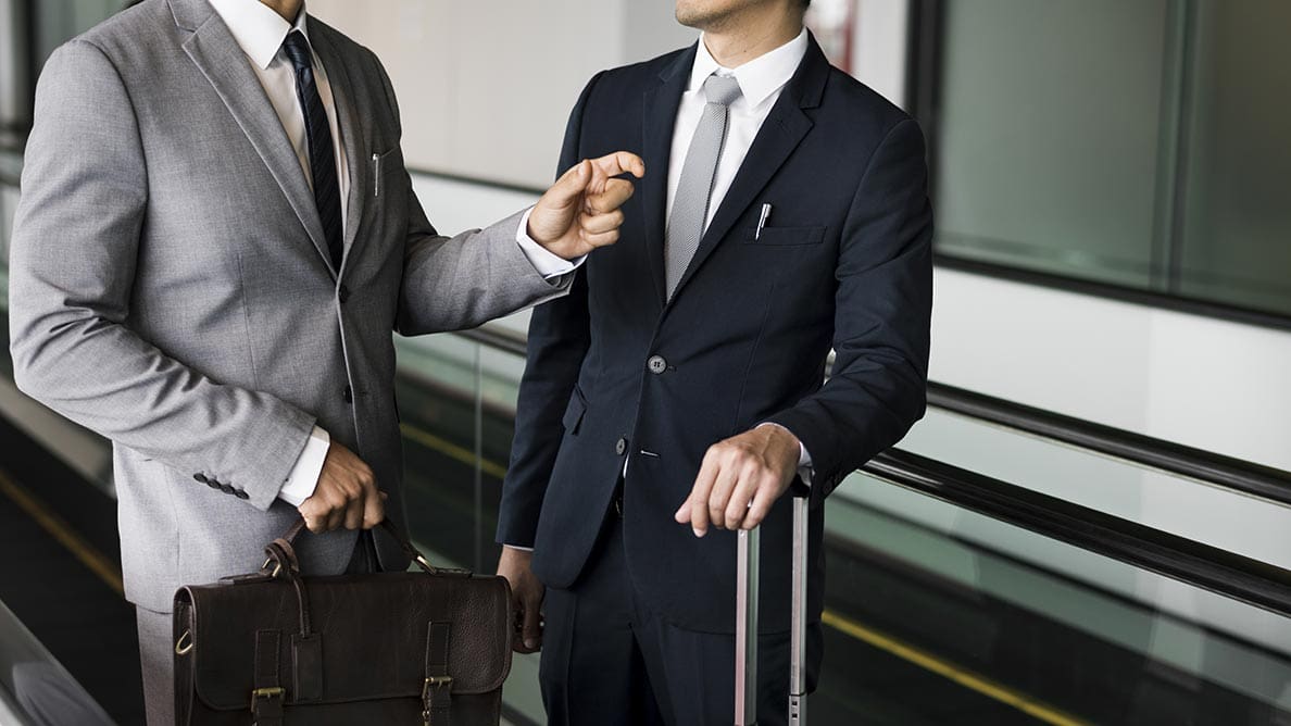 2 business travel chatting Business travelers with luggage chatting at St. Louis airport, waiting for a private car service to pick them up.